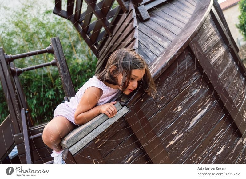 Smiling girl climbing onto wooden playground child fun activity kid smile sport happy little entertainment park brave lifestyle playful courageous support