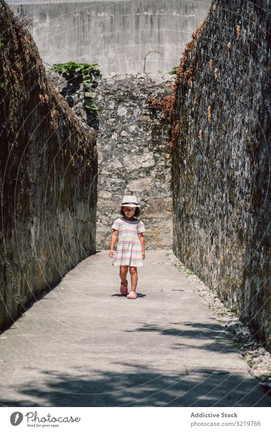 Girl in narrow stone walkway girl adventure happy walking sunlight wall travel tourist nature summer holiday child architecture building destination old