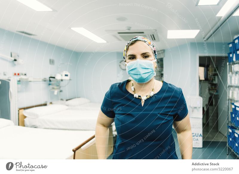 Doctor wearing uniform in hospital room woman doctor medicine clinic mask healthcare treatment job profession occupation adult female attractive positive