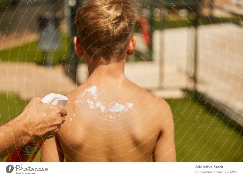 Faceless man applying sun cream on kid father sunblock boy together summer beach protection vacation care help back childhood family suntan leisure relax travel