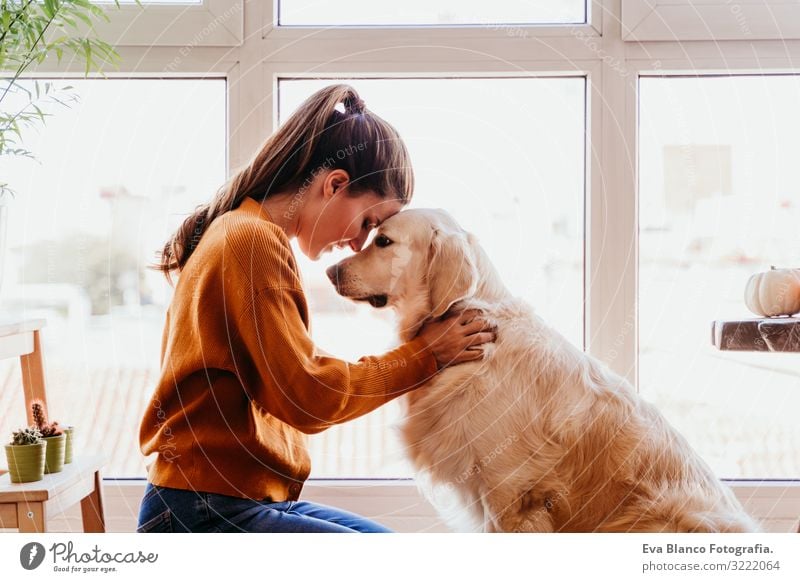 beautiful woman hugging her adorable golden retriever dog at home. love for animals concept. lifestyle indoors Woman Dog Home Golden Retriever Embrace Love