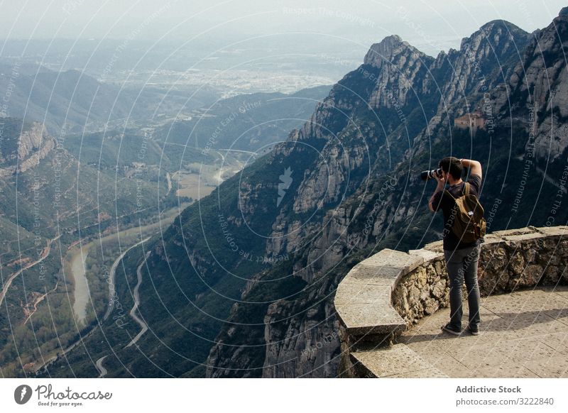 Man photographing landscape from observation deck man taking photo range viewpoint barcelona spain breathtaking ridge travel serene nature photography tourism