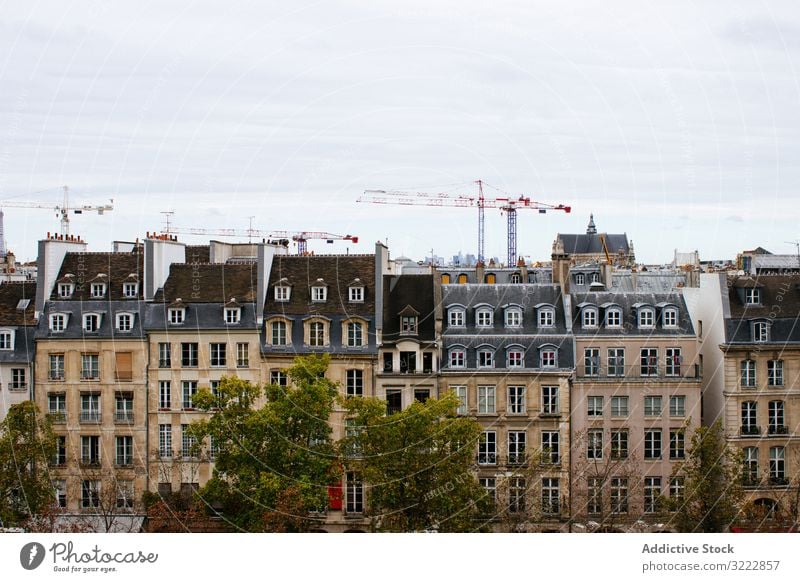 View of typical European buildings architecture house exterior mansard site contrast modern residential europe grey skyline city old town close roof cranes