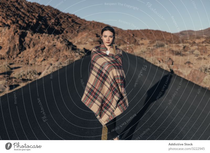Traveler wearing blanket in sun during road trip woman mountains tenerife dream traveler bask young plaid female attractive cold wrapped cozy stand hill spain