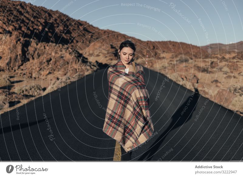 Traveler basking in sun during road trip woman mountains tenerife dream traveler young plaid female attractive cold wrapped cozy stand blanket hill spain