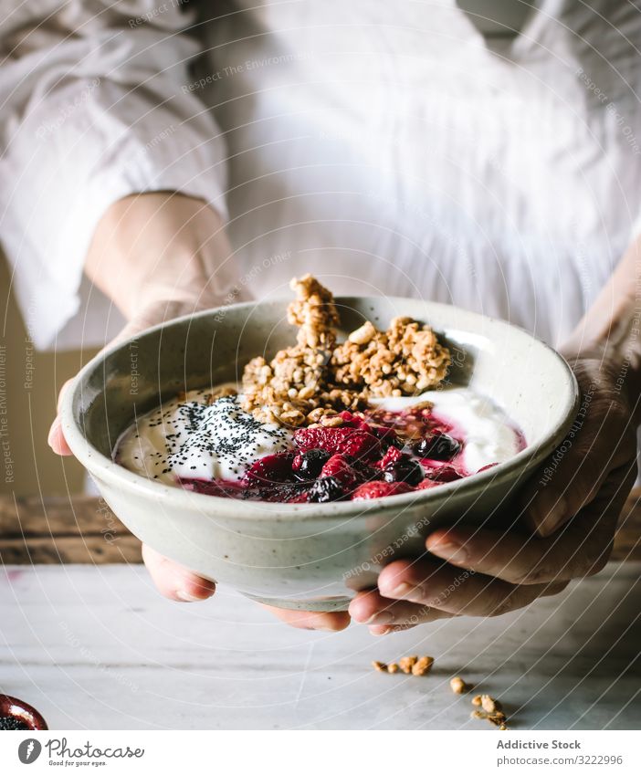 Faceless person with breakfast bowl with quinoa, rice and groats granola food berries chia seed yogurt healthy delicious tasty diet nutrition crunchy crispy