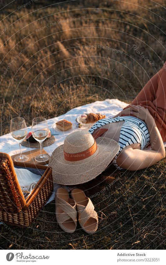Woman resting in meadow on picnic covering face with hat woman summer leisure relax glass drink vacation summertime vintage fashion refreshing watermelon