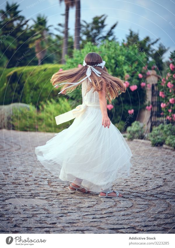 Adorable little girl in airy dress dancing in park child spinning leisure enjoyment happy sweet kid adorable female cute beautiful innocence purity