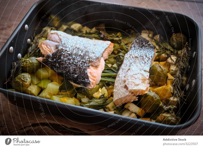 Homemade healthy baked vegetables with red fish salmon piece food skin garnish roasting pan large greens cooked prepared omega cuisine meal wholesome gourmet