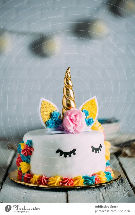 Cute unicorn cake with painted closed eyes sweet tasty birthday bright table appetizing holiday decoration gourmet yummy childhood event festive funny cooking
