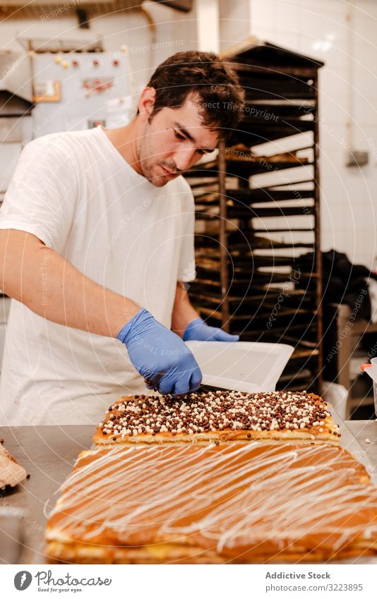 Anonymous baker spreading sprinkles on pastry confectioner bakery decor table quality cake preparation small business fresh occupation traditional work job