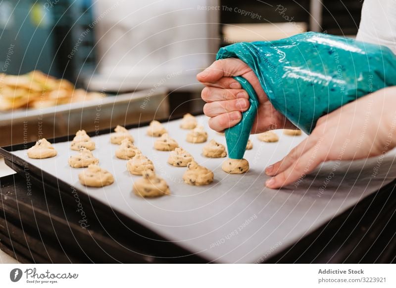 Crop baker squeezing dough on tray confectioner bakery squeeze cookie work kitchen preparation professional cuisine food paper pastry restaurant sweet chef