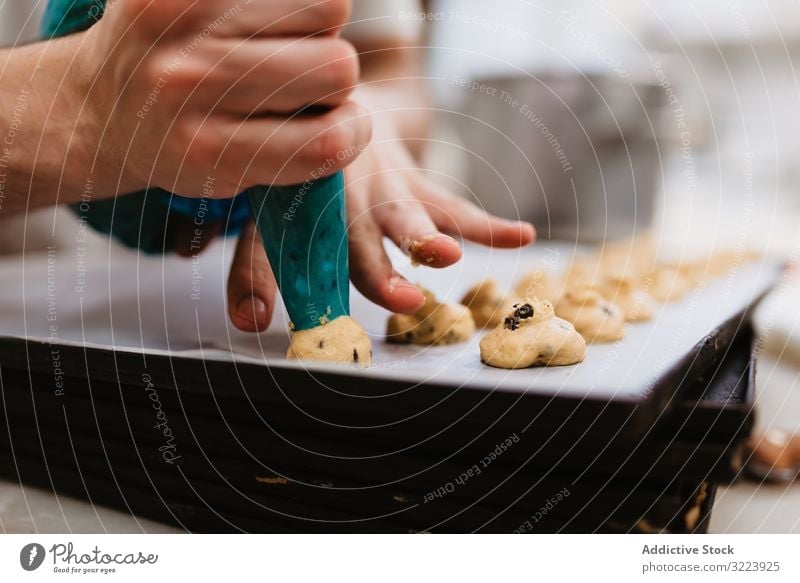Crop baker squeezing dough on tray confectioner bakery squeeze cookie work kitchen preparation professional cuisine food paper pastry restaurant sweet chef