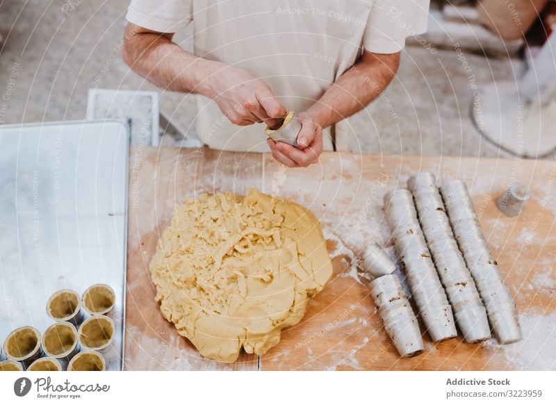 Unrecognizable cook putting pastry dough in cup confectioner bakery table kitchen preparation fresh man raw cuisine professional food chef restaurant cafe flour