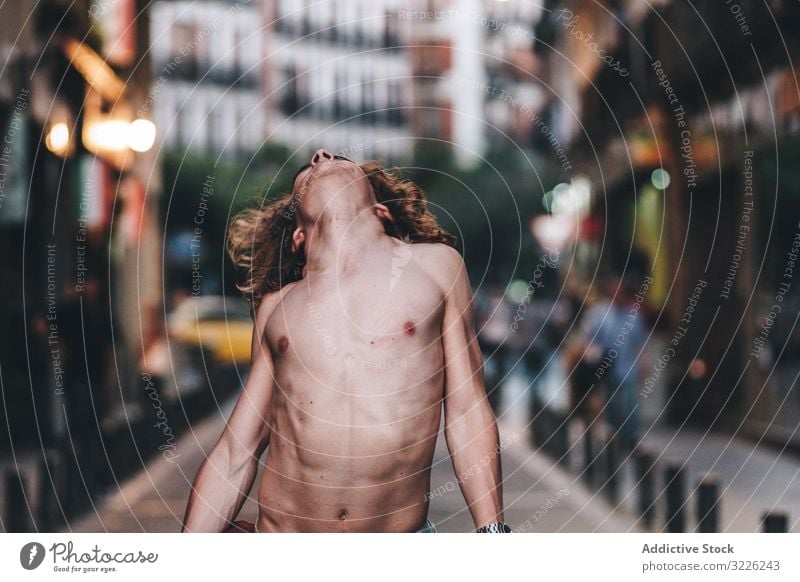 Sensual man and dancing shirtless on street sensual gaze confident pensive naked stand handsome urban long hair young adult day desire passion sexual body torso