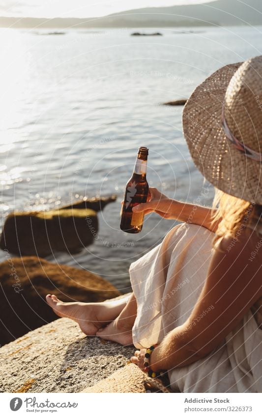 Woman relaxing and drinking beer at beach woman coast seaside lounge refreshment chill sunlight enjoy solitude bottle travel alcohol holidays trip vacation