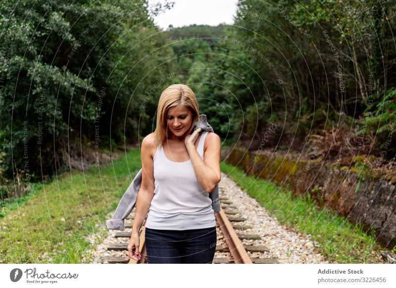 Woman walking along railway though greenery part of road woman extreme forest travel journey grove railroad voyage transport passenger trip smart tourism steel