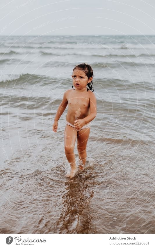 Girl walking on water with unhappy face girl holiday beach summer splashing travel ocean vacation child sea relax sand tan freedom paradise relaxation step