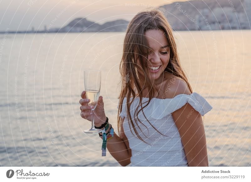 Young woman enjoying wine near sea resort happy evening young female pleasure glad wineglass goblet drink beverage alcohol weekend vacation holiday lady elegant