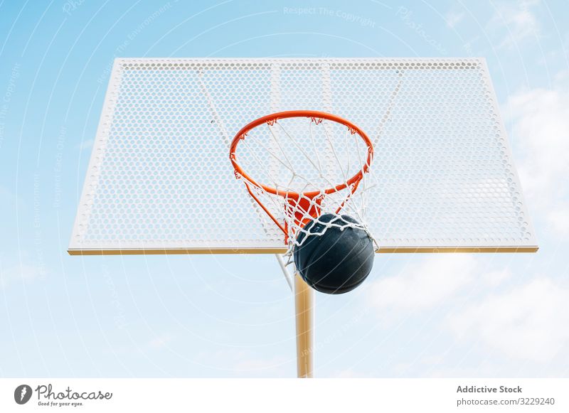 ball into basket in Outdoor basketball court and black ball man athlete competition sports equipment adult recreation action portrait active activity asphalt