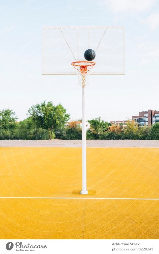 Outdoor yellow basketball court and black ball man athlete competition sports equipment adult recreation action portrait active activity asphalt athletic city