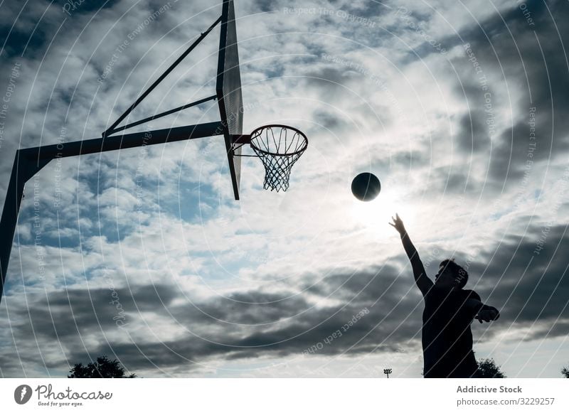 Young man playing on basketball court outdoor. athlete competition sports equipment adult recreation action portrait active activity asphalt city drop drops