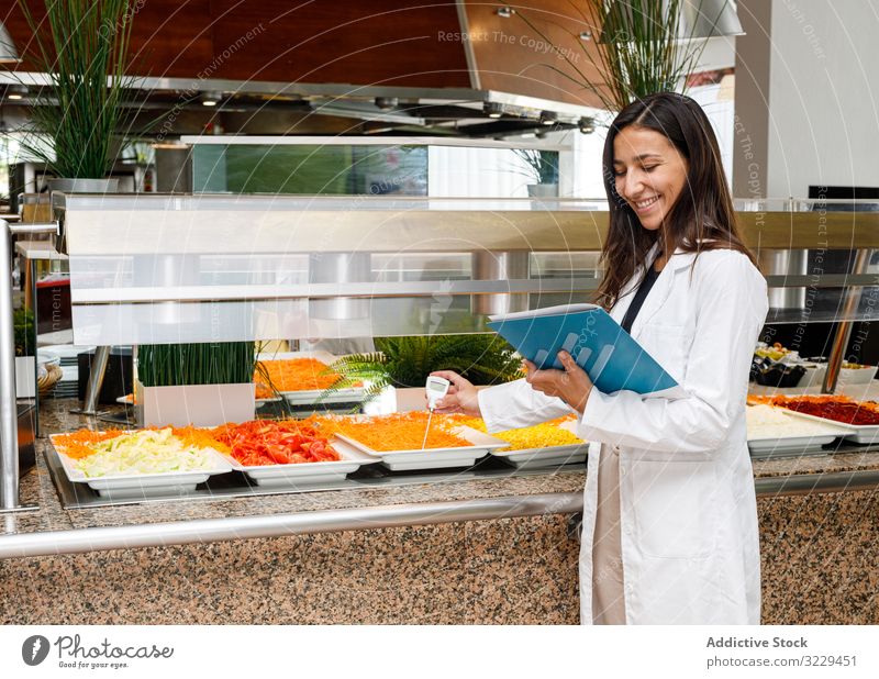Adult employee checking food quality in canteen control test analysis showing report risk prevent product research measurement gadget expert chemical result
