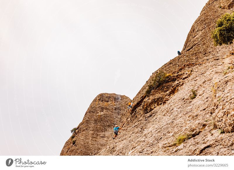 Climbers climbing the mountain of Montserrat, wild danger safety dangerous rocky trekking summer hiker extreme active hiking vertical adventure activity tourist