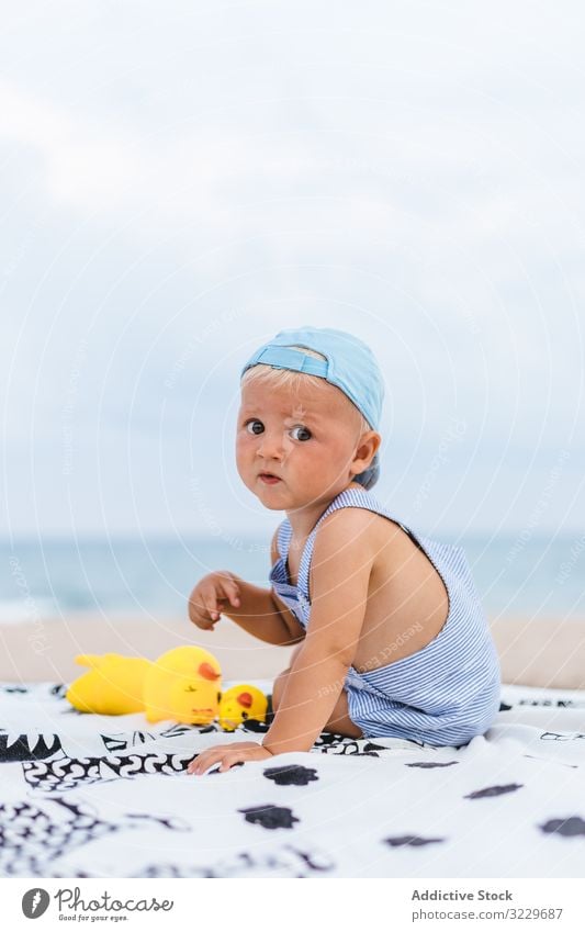 Rear view of a baby with a cap protection boy copy space holidays children kids toys morning caucasian happy back sea childhood people ocean outdoor person