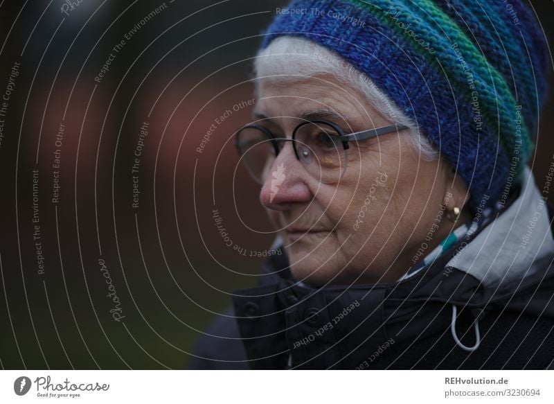 Senior in winter with cap Upper body portrait Shallow depth of field blurriness Day Exterior shot Subdued colour Colour photo naturally Scarf