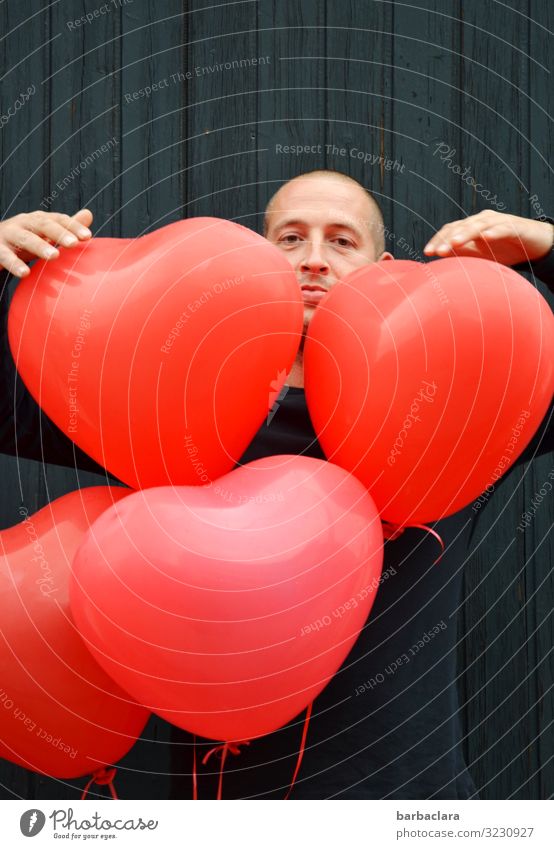 matter of the heart Feasts & Celebrations Man Adults 1 Human being Wall (barrier) Wall (building) Facade Decoration Balloon Heart Looking Stand Red Black