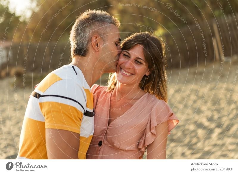 Laughing couple hugging on sandy beach resort smile happy laugh fun love vacation sunny daytime man woman adult honeymoon summer nature shore coast relationship