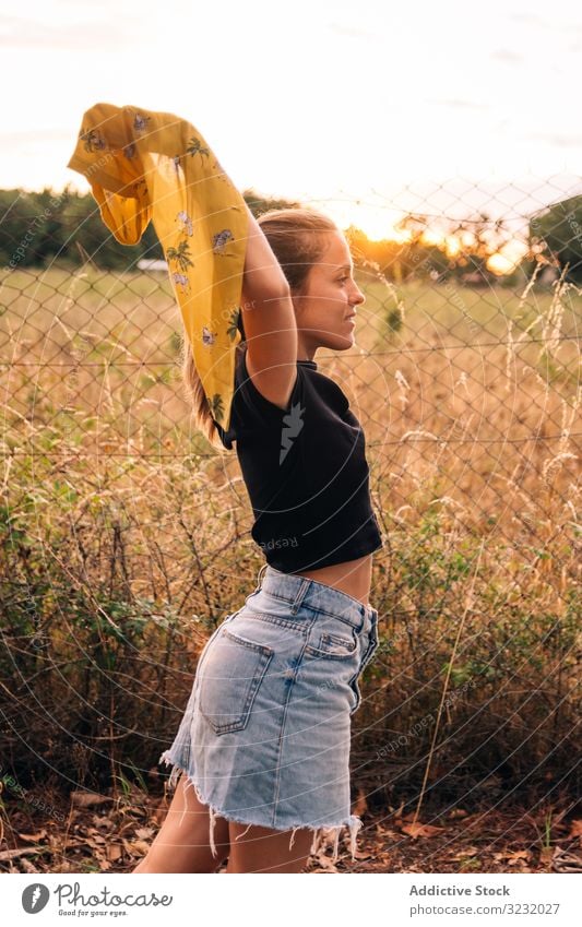 Happy female on meadow in summer woman field happy content casual shirt romantic take off bronzed fence metal chain link nature countryside beauty leisure