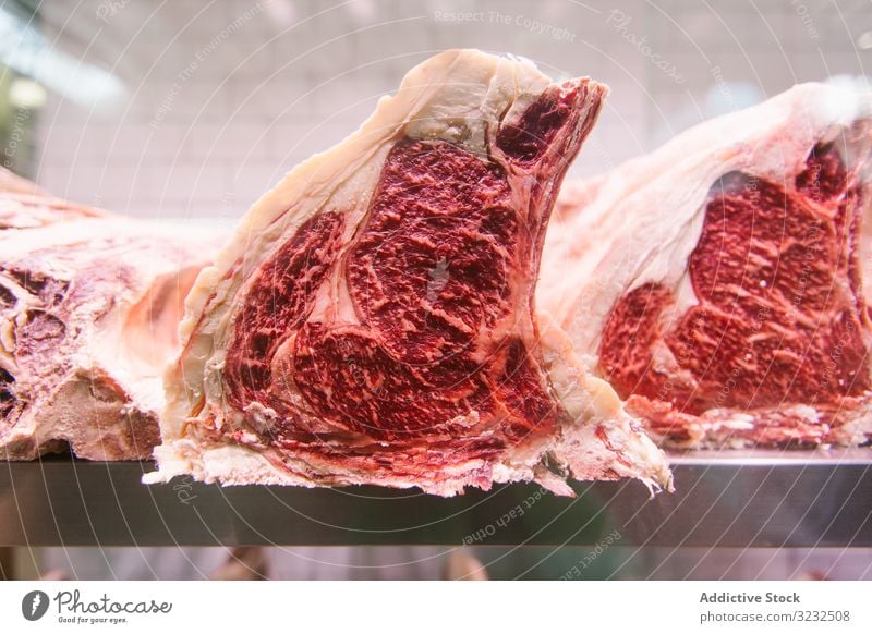 Raw meat on a butcher's chiller for maturing t-bone steak madure loin aged butchery cut fresh beefsteak uncooked protein cow fillet tenderloin food raw sirloin