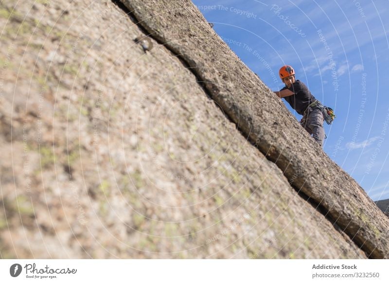 Man climbing a rock man sport mountaineering adrenaline aspiration male difficult strength strong athletic person active sky adventure nature training outdoor