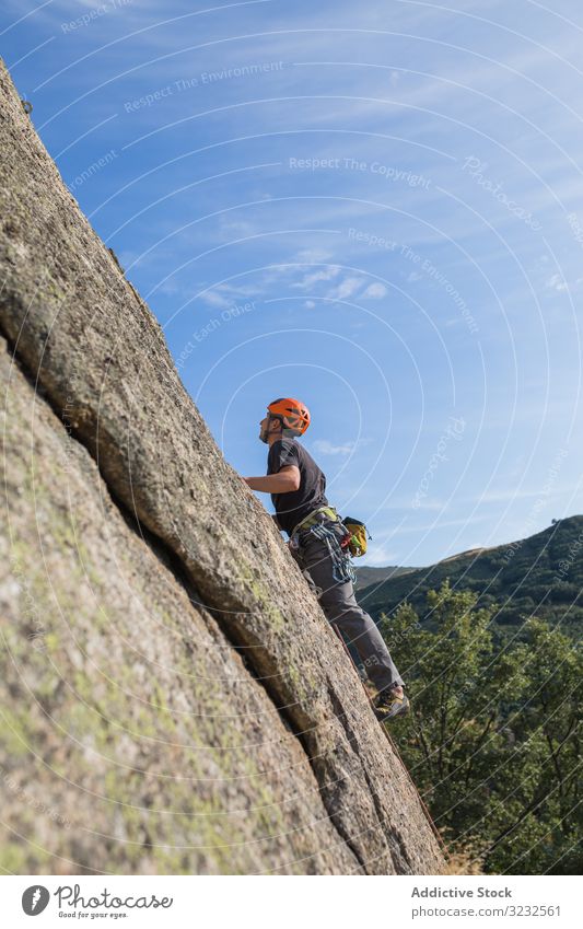 Man climbing a rock man sport mountaineering adrenaline aspiration male difficult strength strong athletic person active sky adventure nature training outdoor