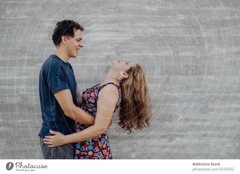 man and woman hugging at nearby street wall couple fun cheerful excited playful people crazy successful content joyful triumph casual achievement enjoying funny