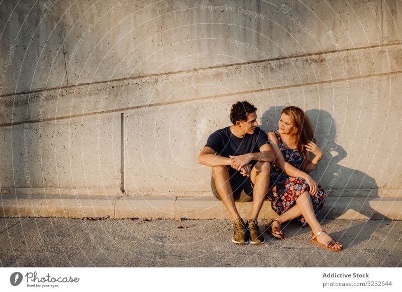 man and woman sitting at nearby street wall couple fun cheerful excited playful people crazy successful content joyful triumph casual achievement enjoying funny