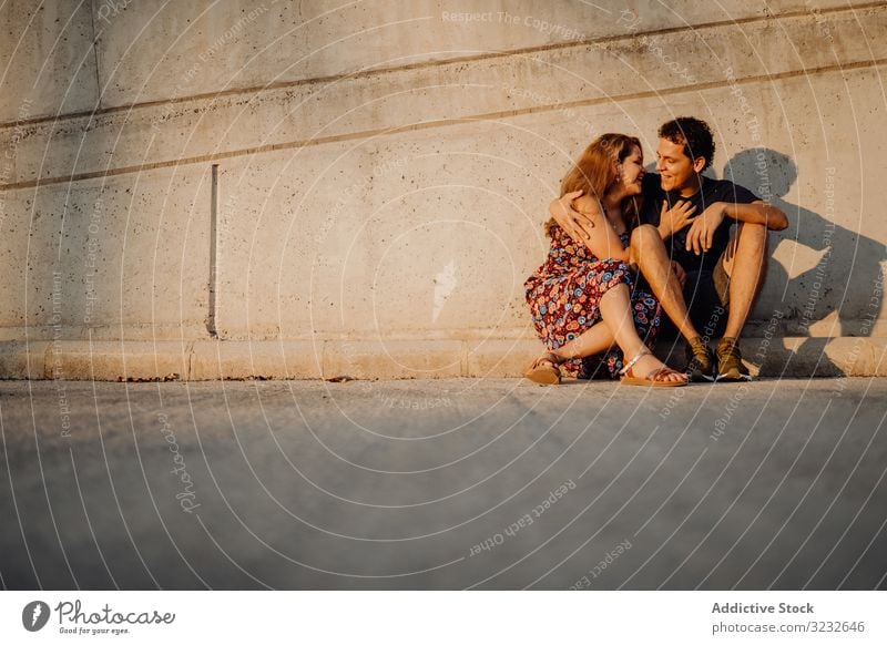 man and woman sitting and embracing at nearby street wall couple fun cheerful excited playful people crazy successful content joyful triumph casual achievement
