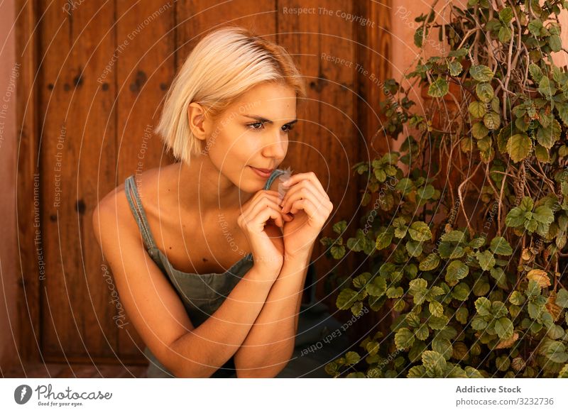 Young female sitting on doorstep woman plant yard garden suburb flora growth vegetation young horticulture estate home cozy blond harmony idyllic dreamy lady