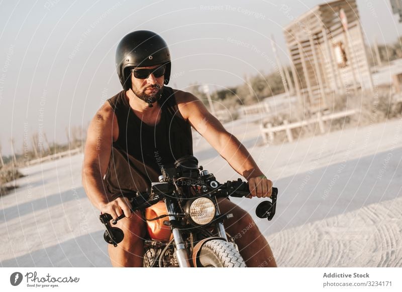 Strong man driving motorcycle drive road sunglasses serious strong male beard ride deserted transport bike biker freedom travel engine power transportation