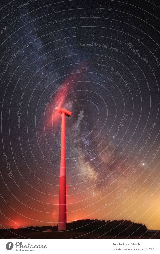 Illuminated wind turbine over starry night sky illuminated working generator milky way breathtaking landscape sustainable mill innovative technology electricity