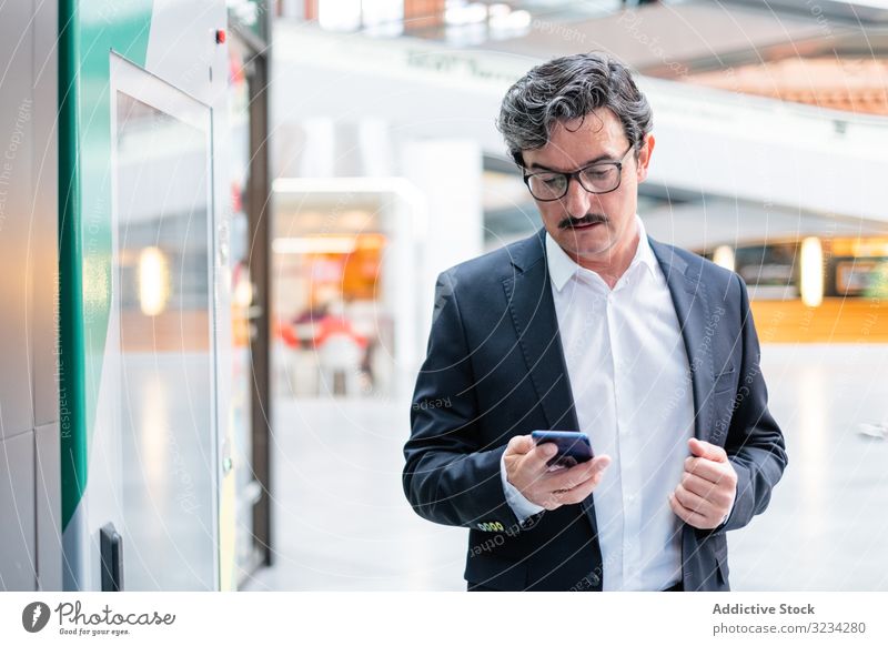 Puzzled senior businessman in stylish formal wear at shopping plaza mall center entrepreneur store contemporary customer purchase eyeglasses standing weekend