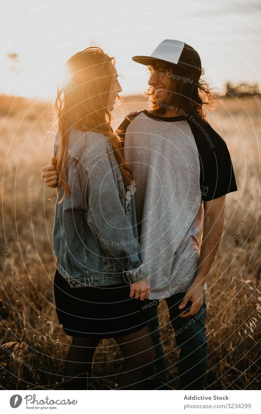 Hipster teenage couple bonding on field in sunlight rural embrace sunset hipster relationship summer generation romantic freedom style cool sensual together