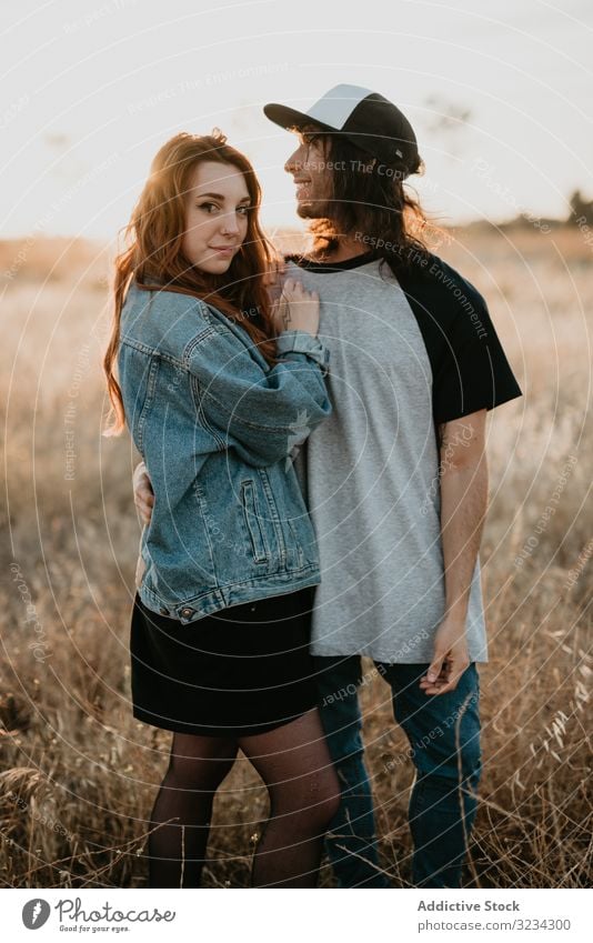 Hipster teenage couple bonding on field in sunlight rural embrace sunset hipster relationship summer generation romantic freedom style cool sensual together