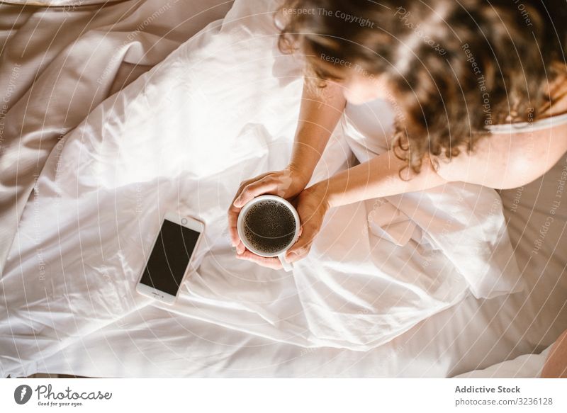 Woman having hot drink and using smartphone in bed coffee use woman message home text information check focus share browsing blank screen surfing social media