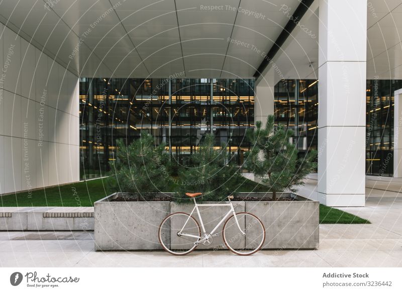 Bicycle parked outside modern building bicycle street city sidewalk urban transport exterior contemporary downtown commute structure construction pavement path