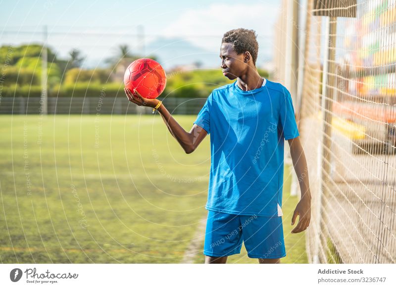 Black teenager on football field lean net training sportswear ethnic grass male adolescent soccer lawn sunny daytime black african american competition workout