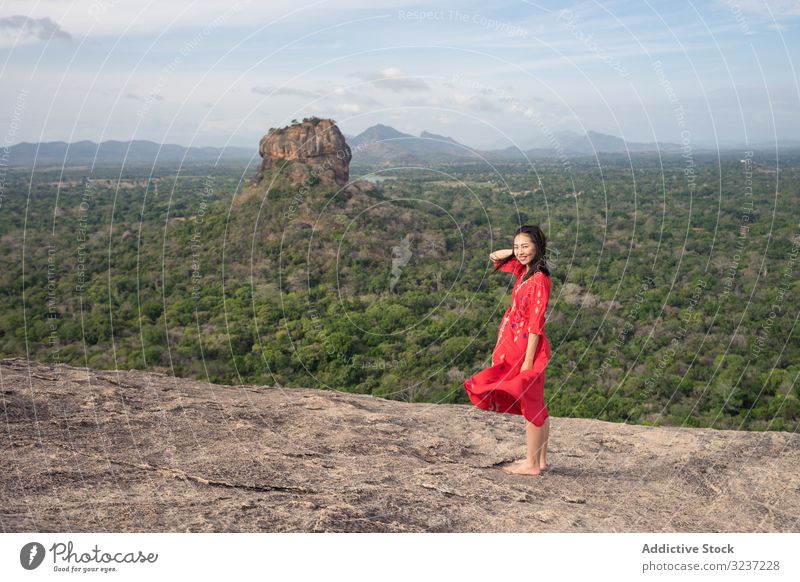 Tourist against solitary rock in middle of green forested plain under clear sky in summer tourism mountain plateau woman travel height sigiriya pidurangala
