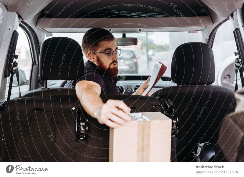 Courier preparing cartons for express delivery man courier write box pensive check marker street prepare order service attentive job distribution package male